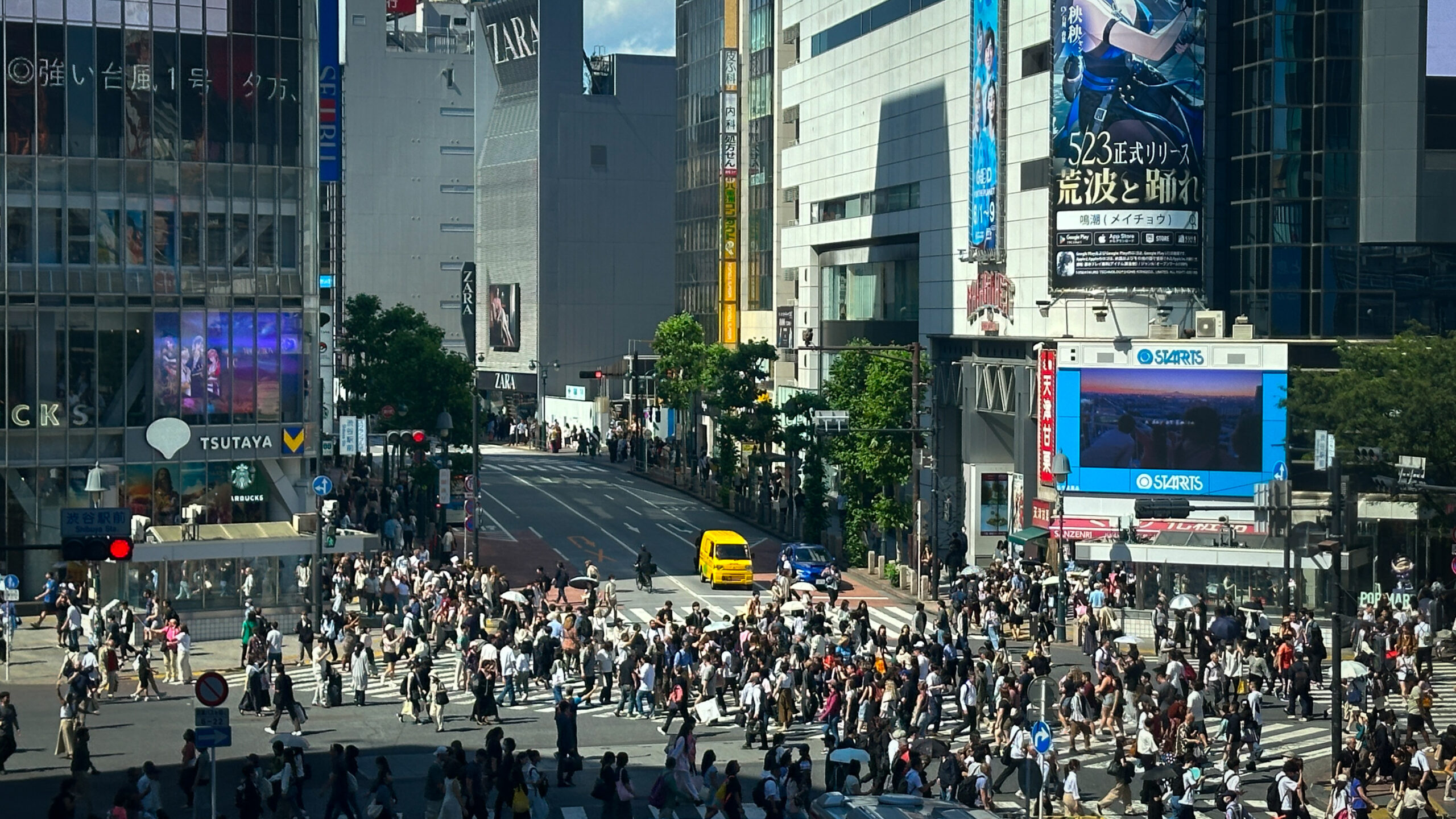 Mucha gente cruzando el cruce de shibuya con edificios modernos de fondo